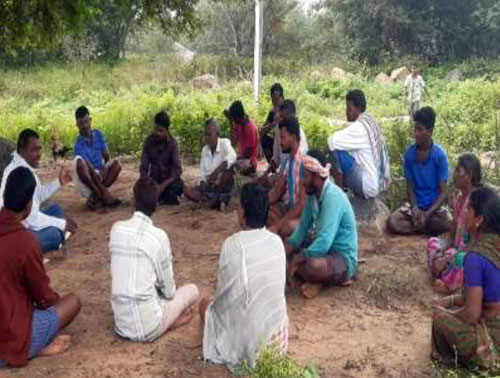 Community members in a field meeting